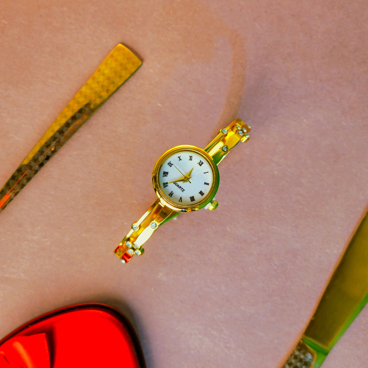 Gold wristwatch on a person's wrist with a blurred background